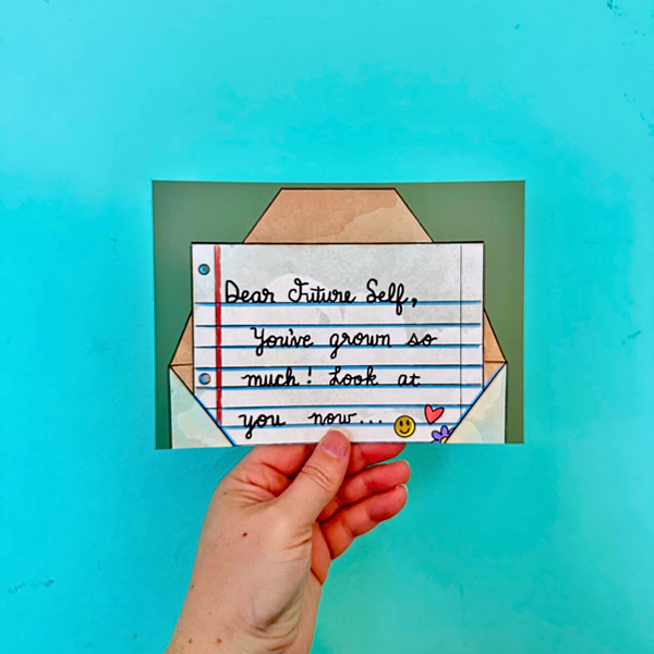 Hand holding a card with a handwritten message on a teal background