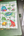 Sheet of frog-themed stickers by Penpal Press on a green notebook with pens beside it.