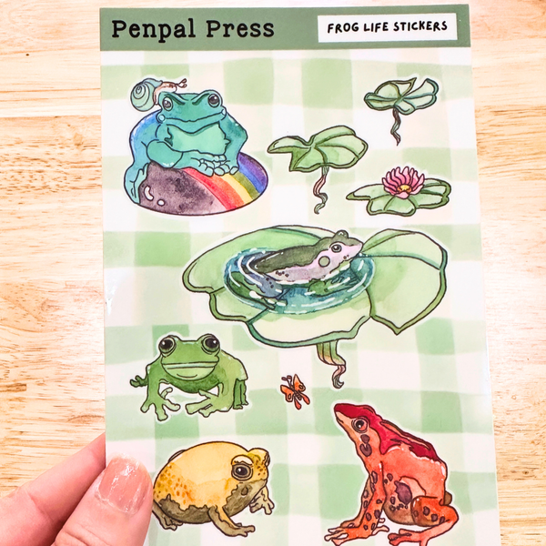 Sheet of frog-themed stickers by Penpal Press on a checkered background