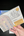 Hand holding a paint palette and watercolor set packaging on a dark surface