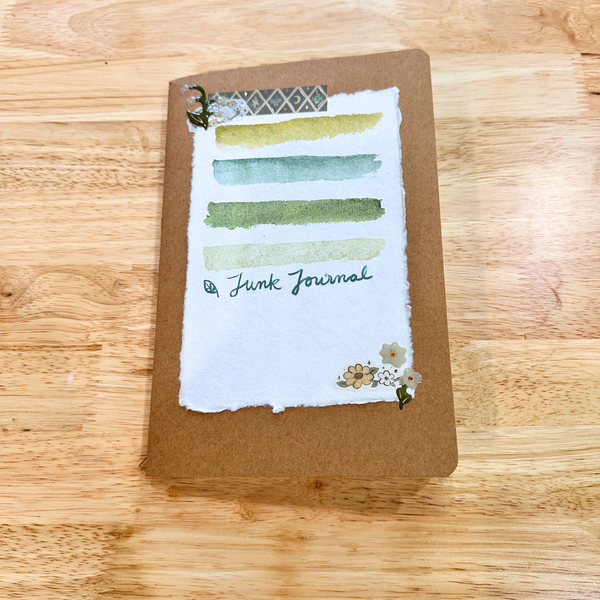 Brown notebook with watercolor design on a wooden surface