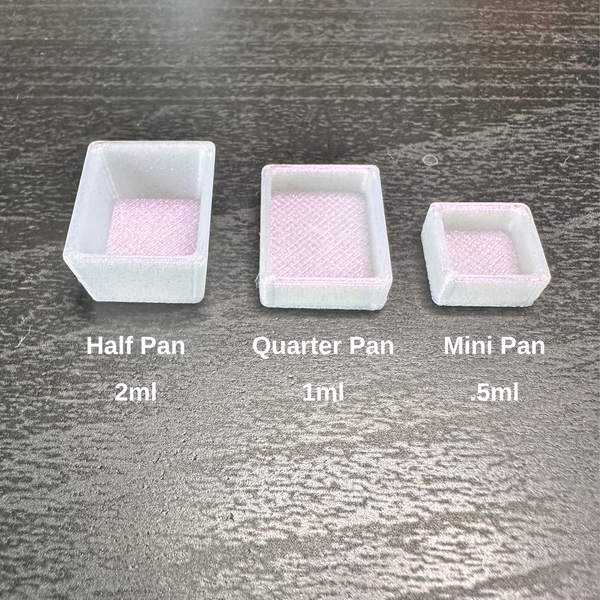 Three small translucent square pans in different sizes labeled Half Pan (2ml), Quarter Pan (1ml), and Mini Pan (.5ml) on a dark textured surface.