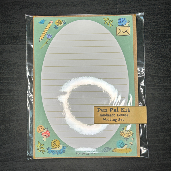 Pen Pal Kit with lined paper and stationery items on a dark surface
