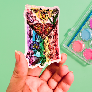 Colorful Pride Flag butterfly and flower sticker held by a hand with a green background and paint palette.