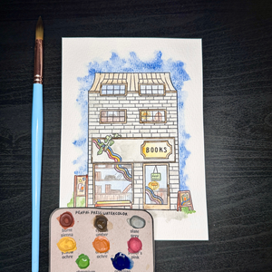 Watercolor illustration of a bookstore with a paintbrush and color swatch on a dark surface