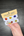 Hand holding a paint set with colorful dots on a dark wooden surface