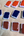 Newly filled quarter pans of watercolor paint in venetian red, Prussian blue, and violet hematite. Pans are laid out in rows on top of chipboard.