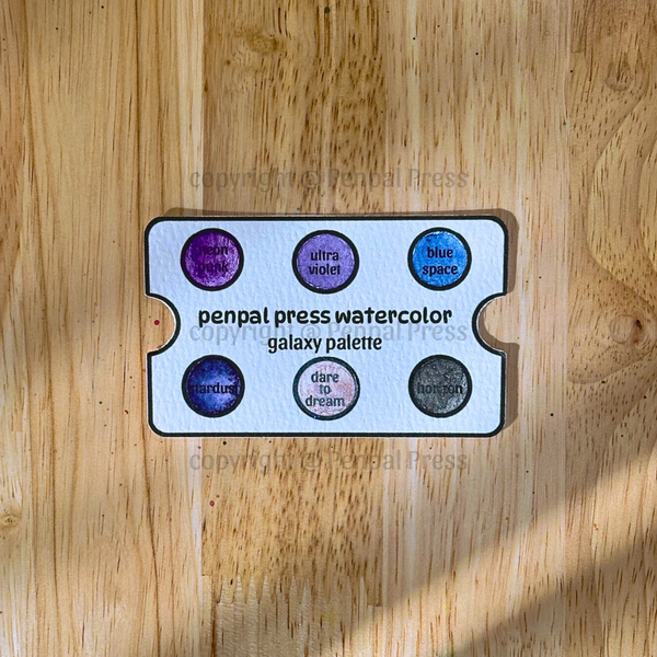Penpal Press watercolor galaxy palette on a wooden surface