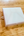 White iridescent paint box on wooden surface.