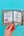 Hand holding a small open book with illustrations on a teal background