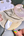 Close up of a glass slab with palette knife, heart shaped measuring spoon, glass muller, and half empty paint pan set.