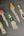 Set of five ceramic or stone tools with different designs on a textured surface