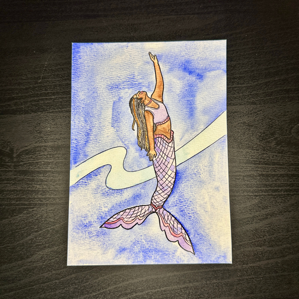 Colorful painting of a mermaid on a wooden surface