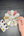 Hand painting on a ceramic flower with a brush on a gray surface