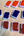 A collection of rectangular paint pains with glossy wet handmade paint in various colors including orange, dark blue, and reddish-brown, arranged on a textured kraft surface.