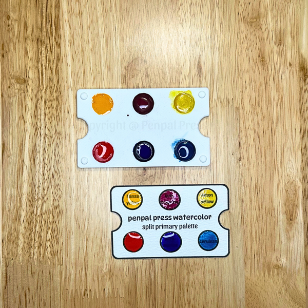 penpal press watercolor split primary palette on a wooden surface