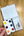 Open Penpal Paint Box with a hand holding a split primary palette on a wooden surface.