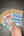 Hand holding a collection of Penpal Press washi tape samples on a wooden surface