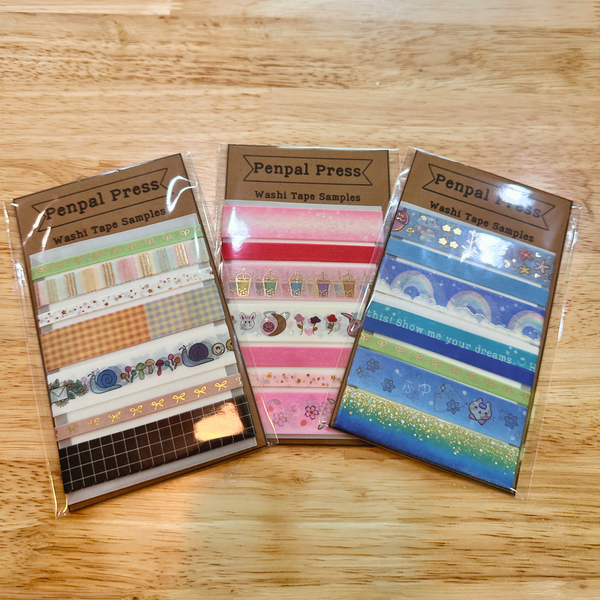 Three packages of Penpal Press washi tape samples on a wooden surface