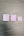 Three small white plastic pans for watercolor, arranged by size on a dark gray wood-grain surface.